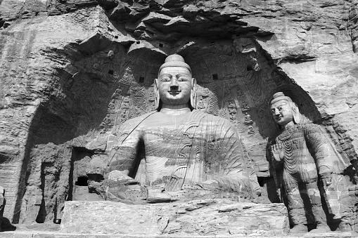 Close-up of the 13.7-meter-tall colossal Buddha of Cave 20, an icon of Chinese art, excavated from the sandstone cliff at Yungang Grottoes, ancient Chinese Buddhist temple grottoes built during the Northern Wei dynasty near the city of Datong, in the province of Shanxi. They are excellent examples of rock-cut architecture and one of the three most famous ancient Buddhist sculptural sites of China. The others are Longmen and Mogao.