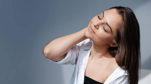 istock Smiling girl posing with closed eyes on grey background 2025509658