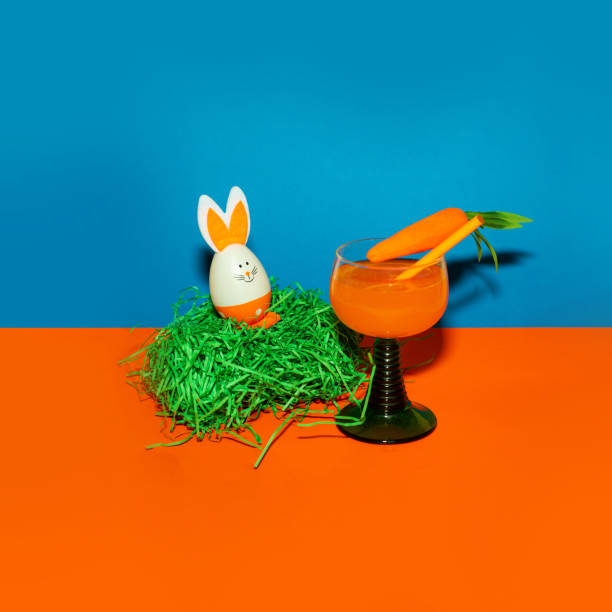 istock Easter egg and carrot in a glass on a colored background. 2025537757
