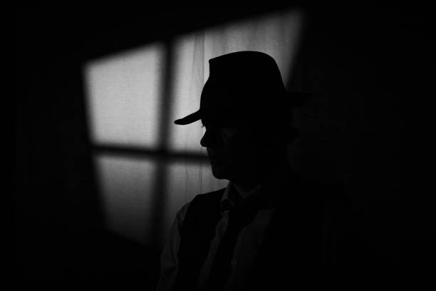 film noir detective in dark office - achterdocht fotos stockfoto's en -beelden