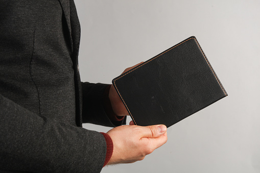 Business man holding black leather notebook