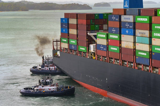 Colon, Panama - 22 January 2024: Tug boats assiting a large container ship to pass through the Agua Clara locks on the Panama Canal