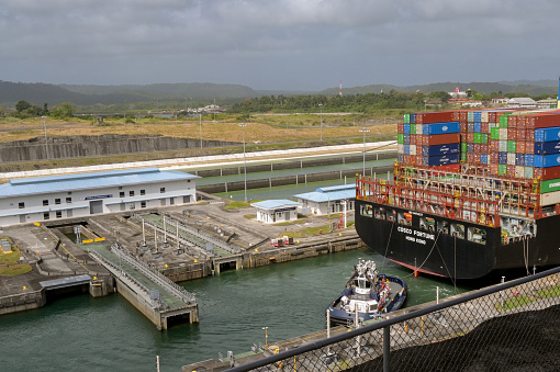 Colon, Panama - 22 January 2024: Tug boat assiting a large container ship Costco Fortune to pass through the Agua Clara locks on the Panama Canal
