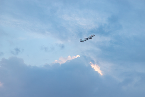 Heraklion, Crete, Greece - October 2, 2023: A picture of a Freebird plane flying overhead between the clouds, at sunset.
