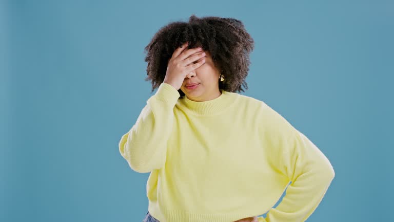 Mistake, fail and woman with face palm in studio for review, feedback or negative results on blue background. Disaster, portrait or model with oops, wrong or stupid emoji, frustrated or disappointed