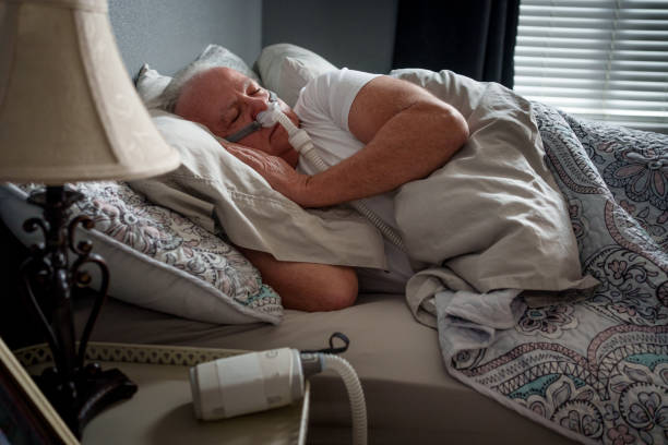 istock Mature Man Sleeping with a CPAP (Continuous positive airway pressure) Machine after being diagnosed with Sleep Apnea 2025681882