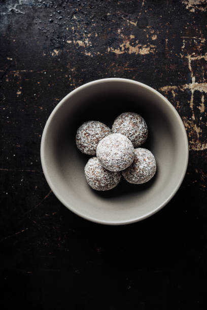 Homemade candies in coconut flakes on a dark background.