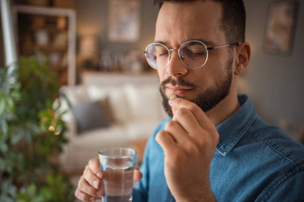 istock The young man takes medication to reduce depression or headaches 2025716947
