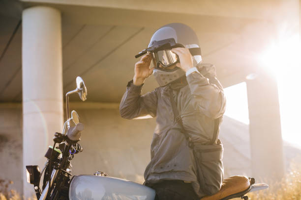 istock A biker puts on a helmet while sitting on a motorcycle.A man rides a motorcycle at sunset. 2025775822