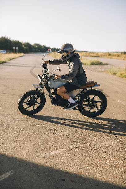 istock Biker on a cafe racer motorcycle on the road at sunset. 2025775861