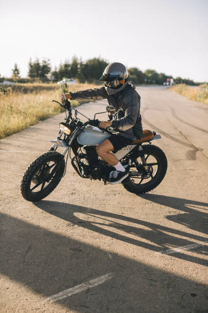istock Biker on a cafe racer motorcycle on the road at sunset. 2025776345