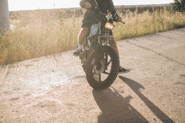 istock Biker on a cafe racer motorcycle on the road at sunset. 2025776350