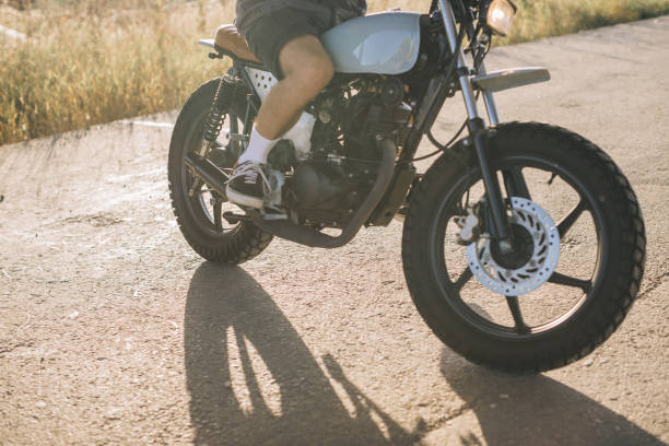 istock Biker on a cafe racer motorcycle on the road at sunset. 2025776355