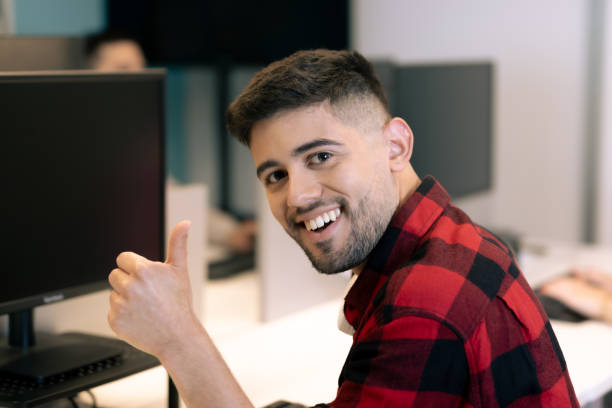 istock Young male office worker raising his thumb in OK symbol. Good work environment concept. 2025821591