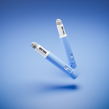 Two injectors / dosing pens  for subcutaneous injection of antidiabetic medication or anti-obesity medication hovering over a blue background.