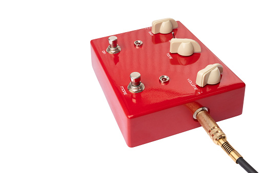 A close-up of a red guitar effects pedal on a white background.
