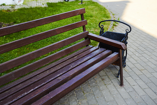 Photo a wooden brown bench in the park. A place to relax. A day in summer.