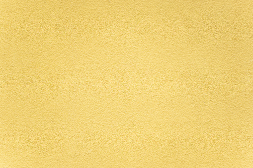 Rough plaster wall painted in yellow
