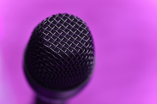 Close up photo of microphone on purple background