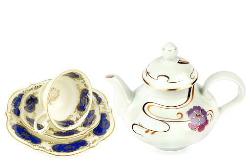 Vintage bone China teapot and a cup and saucer - studio shot with a white background