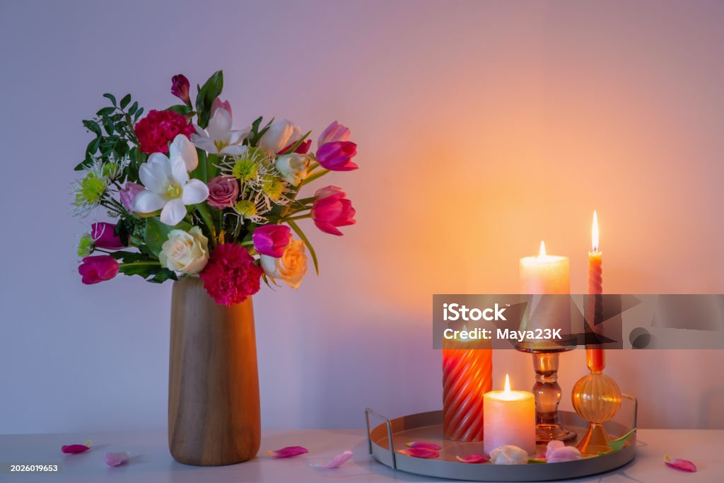 flowers in vase and burning candles on shelf on background wall - Lizenzfrei Baumblüte Stock-Foto flowers in vase and burning candles on shelf on background wall - Lizenzfrei Baumblüte Stock-Foto