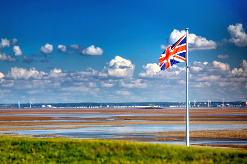 A Union Flag (sometimes known as the Union Jack, the flag of the United Kingdom), flies in a property on the coast of South Wales.  The coast in the distance is England.   This estuary is extremely dangerous for skippers who dont know it and many ships have come to grief; it has one of the biggest dialy tidal rises and falls in the world.