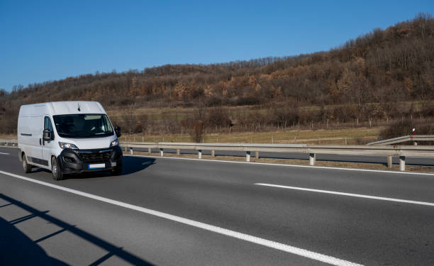 istock White modern delivery small shipment cargo courier van moving fast on motorway road to city urban suburb. 2026050650