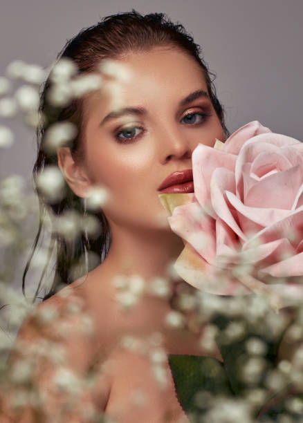 istock A beautiful woman with a big rose on her cheek. 2026051736