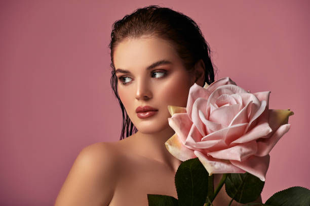 istock A beautiful woman holding a big rose in her lap. 2026054052