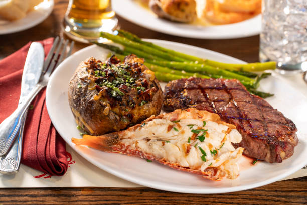 rib eye steak, lobster tail and stuffed baked potato dinner - lobster steak lobster tail barbecue grill imagens e fotografias de stock