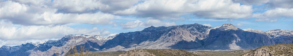 Panorama of distant mountains in desert of Arizona with a light dusting of snow.