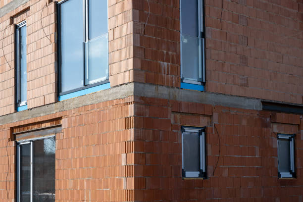 istock facade of a new private house built with modern red clay ceramic bricks before insulation works. Energy efficient wall and New windows. 2026073330