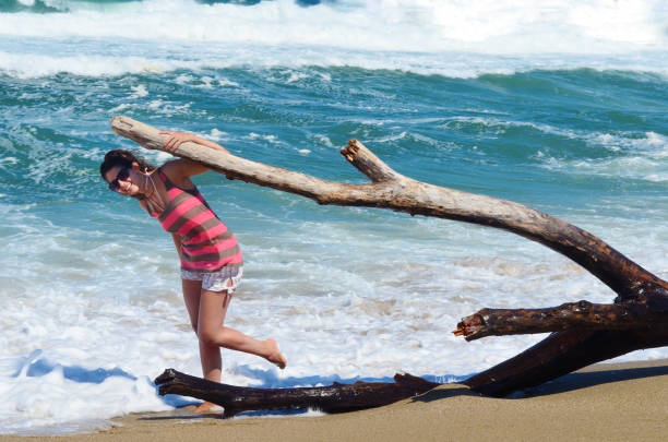 Woman sitting on a beach with big waves