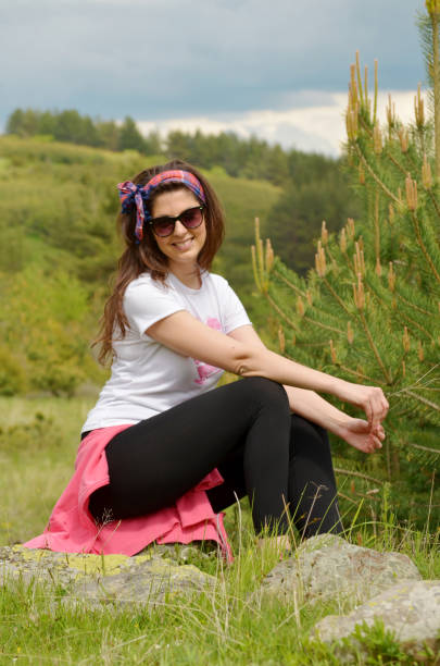 Mature Woman sitting  in the summer  mountain .