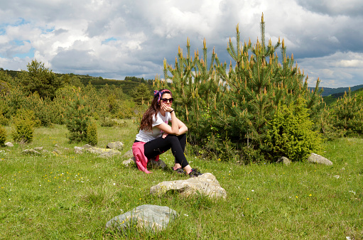 Mature Woman sitting  in the summer  mountain .