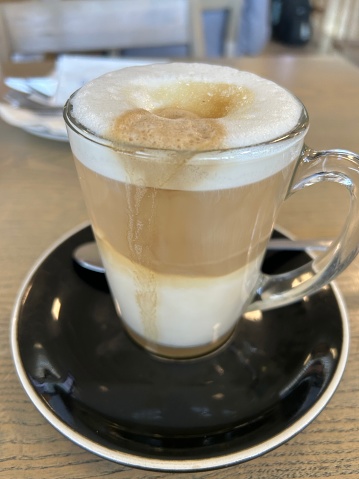 Coffee in a glass with layers of milk, foam and coffee