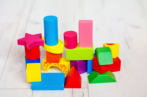 Heap of wooden toy blocks on blue background.