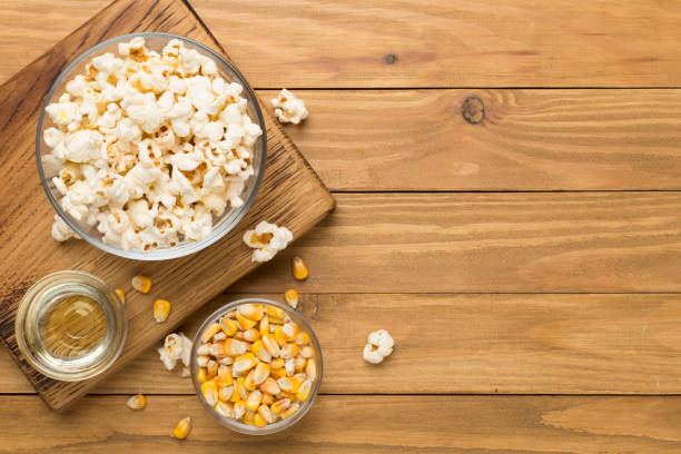 istock Prepared popcorn with ingredients on wooden background, top view 2026122239