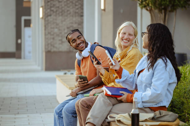 istock Group of students using smart phones on the street 2026128526