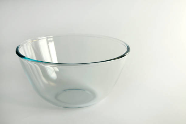 istock An empty glass bowl for mixing salad and various vegetables. Front view 2026135368