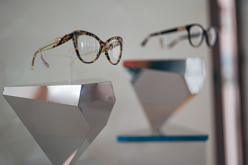 An assortment of fashionable sunglasses of different colors and styles are put up for sale on the store counter