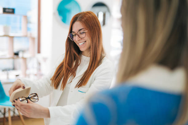 Woman choosing eyeglasses frames in a modern optical store.