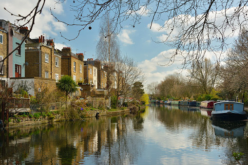 Terrace houses and narrowboats in the Grand union canal, Regent's canal from Meanwhile Gardens, Westbourne Park, London, UK