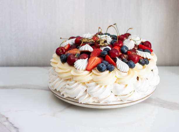 pavlova cake with whipped cream cheese, chocolate sauce, fresh strawberry, blueberry and raspberry, decorated with meringues on plain background - large cheese beautiful red zdjęcia i obrazy z banku zdjęć
