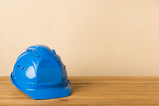 Blue construction helmet on wooden table