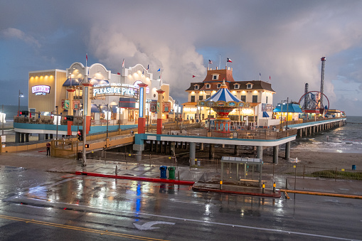 Galveston, USA - October 29, 2023: Pleasure Pier seen from the water in Galveston Island by bad weather conditions., Texas, USA.
