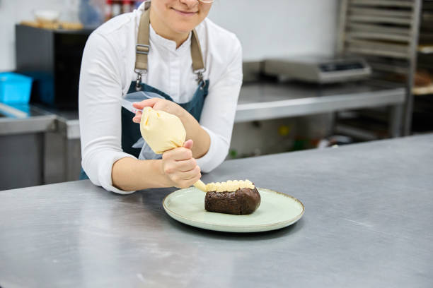 Female baker filling pastry with cream