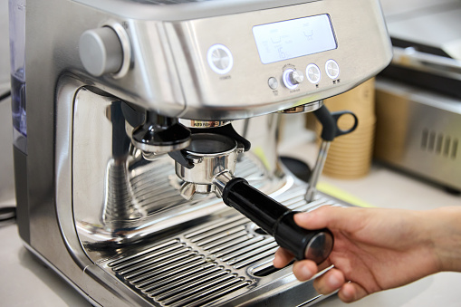 Barista preparing a cup of coffee in a machine