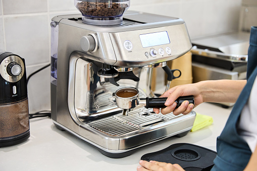 Barista preparing a cup of coffee in a machine