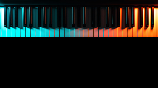 Keyboard instrument (piano, grand, synthesizer) with colored lighting - blue and orange light, low key, minimalistic. Atmospheric music, concert, advertising of music training courses. Copy space.